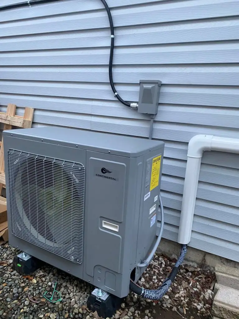 New outdoor heat pump installed beside a home's exterior wall