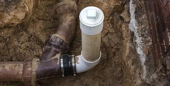 Exterior sump pump discharge pipe connected to underground drainage system - xtraPro