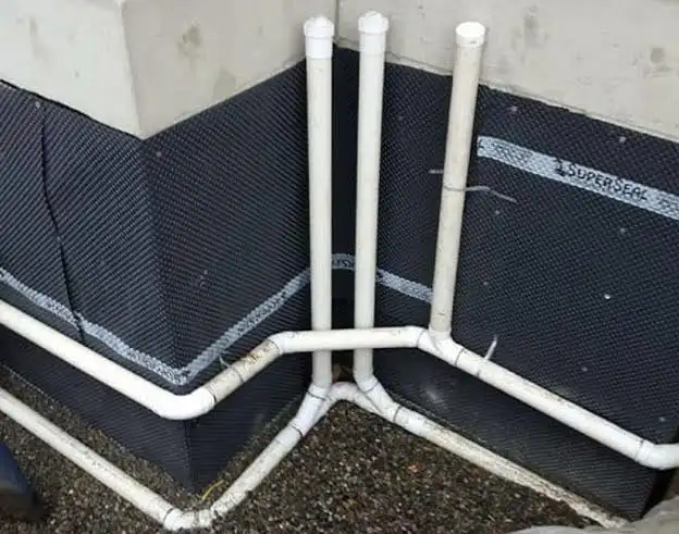 Foundation weeping tile drainage pipes installed around a home's exterior basement wall