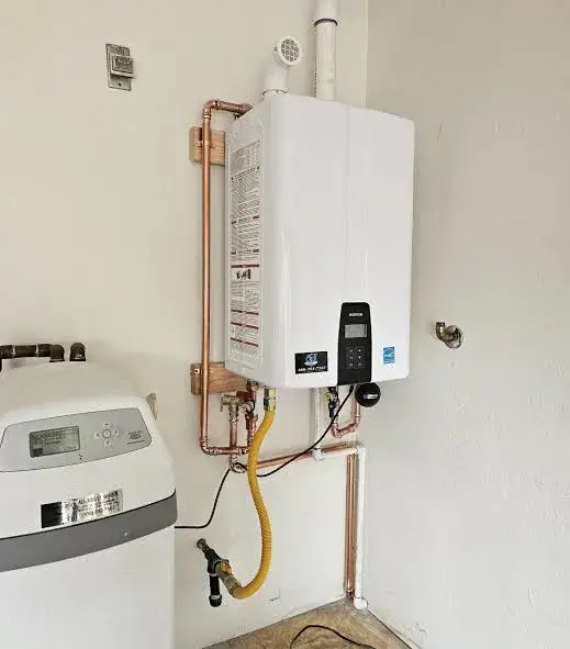 Wall-mounted tankless water heater installed in a residential utility room